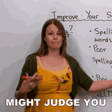 a woman in a yellow dress stands in front of a white board that says improve your grammar might judge you