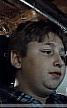 a young boy is sitting in a car looking at the camera .