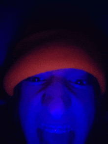 a person wearing a red hat is glowing in a blue light