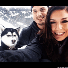 a man and woman are posing for a picture with their dog