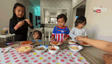 a group of children are sitting at a table with plates of food and a sign that says ' zorro ' on it