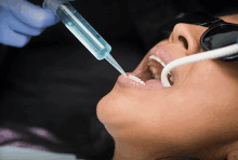 a woman is getting a dental treatment with a syringe that says " panasonic " on it