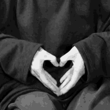 person making a heart shape with their hands