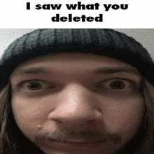 a close up of a man 's face with a hat and mustache .