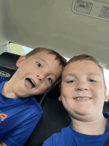 two young boys in a car with a graco seat belt