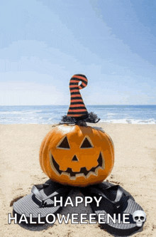 a pumpkin wearing a witch hat sits on a pair of flip flops on a beach