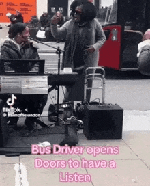 a bus driver opens doors to have a listen while a man sings into a microphone on the sidewalk .