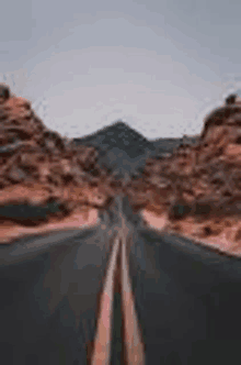 a road in the middle of a desert with mountains in the background