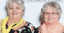 two older women standing next to each other in front of a sign that says ' tsvenska '