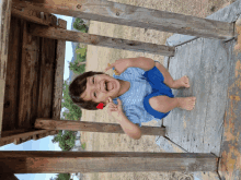 a little boy is sitting under a wooden table with his mouth open