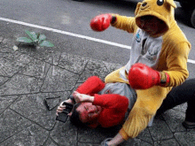 a man in a kangaroo costume is boxing another man in a red shirt