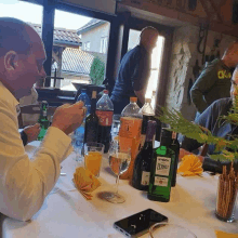 a man sitting at a table with a bottle of fernet