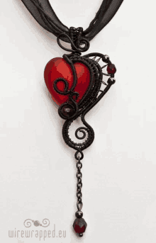 a wire wrapped necklace with a red heart on it