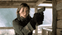a woman is holding a gun in front of a sign that says m.i.t.s.