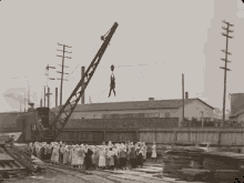 a black and white photo of a group of people standing in front of a building that says company of california