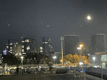 a full moon is visible in the sky above a city