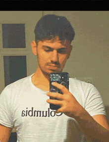 a man taking a picture of himself in a mirror wearing a shirt that says sidmulos