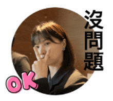 a woman in a suit is making an ok sign with her hand