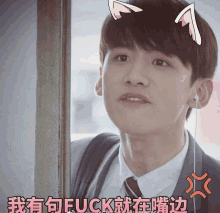 a young man wearing ear buds and a cat ear headband says " fuck " in chinese