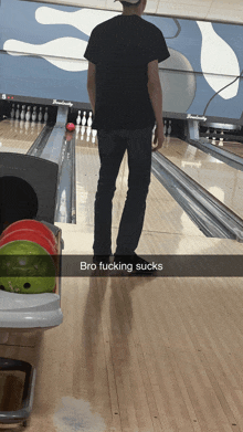 a man standing in a bowling alley with the words bro fucking sucks below him