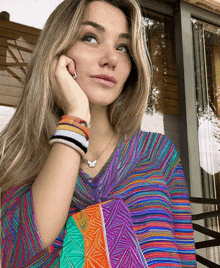 a woman wearing a butterfly necklace and bracelets looks up