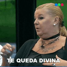 a woman with a tattoo on her chest is saying " te queda divina "