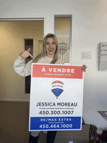 a woman holds up a sign that says a vendre