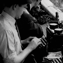 a man is typing on a typewriter in a black and white photo with a atlanta documentary film festival badge