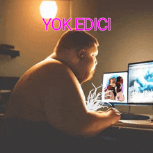 a shirtless man sits in front of a computer with the words yok edici written above him