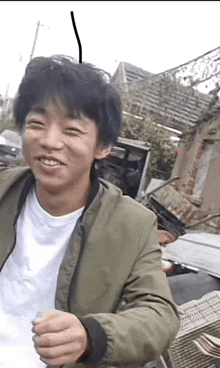 a man wearing a green jacket and a white shirt smiles