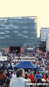 a large crowd of people are gathered in front of a building with the words wir beschutzen diese demokratie written on the bottom