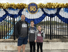 a man and two children are standing in front of a sign that says carwowinde 50