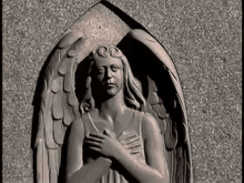 a statue of a woman with angel wings on a wall .