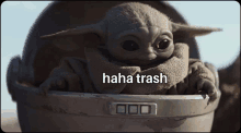 a baby yoda is sitting in a bucket with the words haha trash written on the bottom