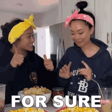 two women giving a thumbs up next to a bowl of chips and the words " for sure " on the table