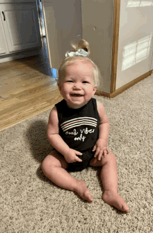 a baby wearing a black tank top that says " good vibes only "