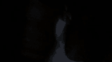 a close up of a person 's face in a dark room .