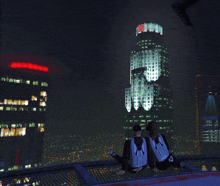 a man and a woman are sitting on top of a trampoline in front of a skyscraper that has a skull on it