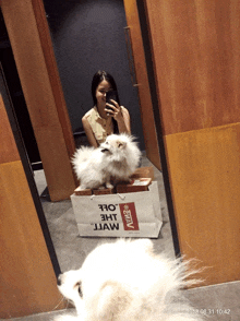 a woman taking a picture of herself and a dog with a bag that says jaw