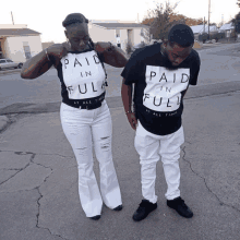 a man and a woman wearing paid in full t-shirts