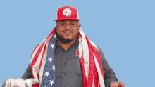 a man with an american flag draped around his neck holding a soccer ball and the word goal behind him