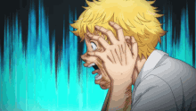 a man with yellow hair is holding his head with his hands