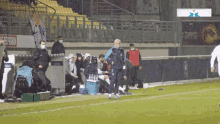 a group of soccer players are on a field with a sign behind them that says ' fc barcelona '