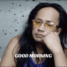 a man with long hair wearing sunglasses and a shirt that says good morning