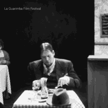 a black and white photo of a man sitting at a table with the words la guarimba film festival written above him