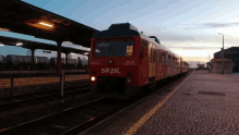 a red train with the letters skpl on the front