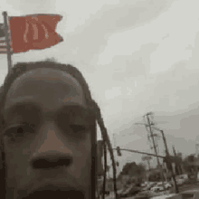 a man is taking a selfie with a mcdonald 's flag on top of his head .