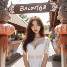 a woman in a white dress is standing in front of a sign that says balon168