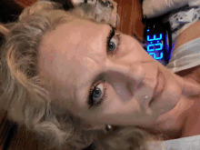 a close up of a woman 's face with a digital clock displaying the time of 3:06