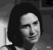 a black and white photo of a woman with short hair making a face .